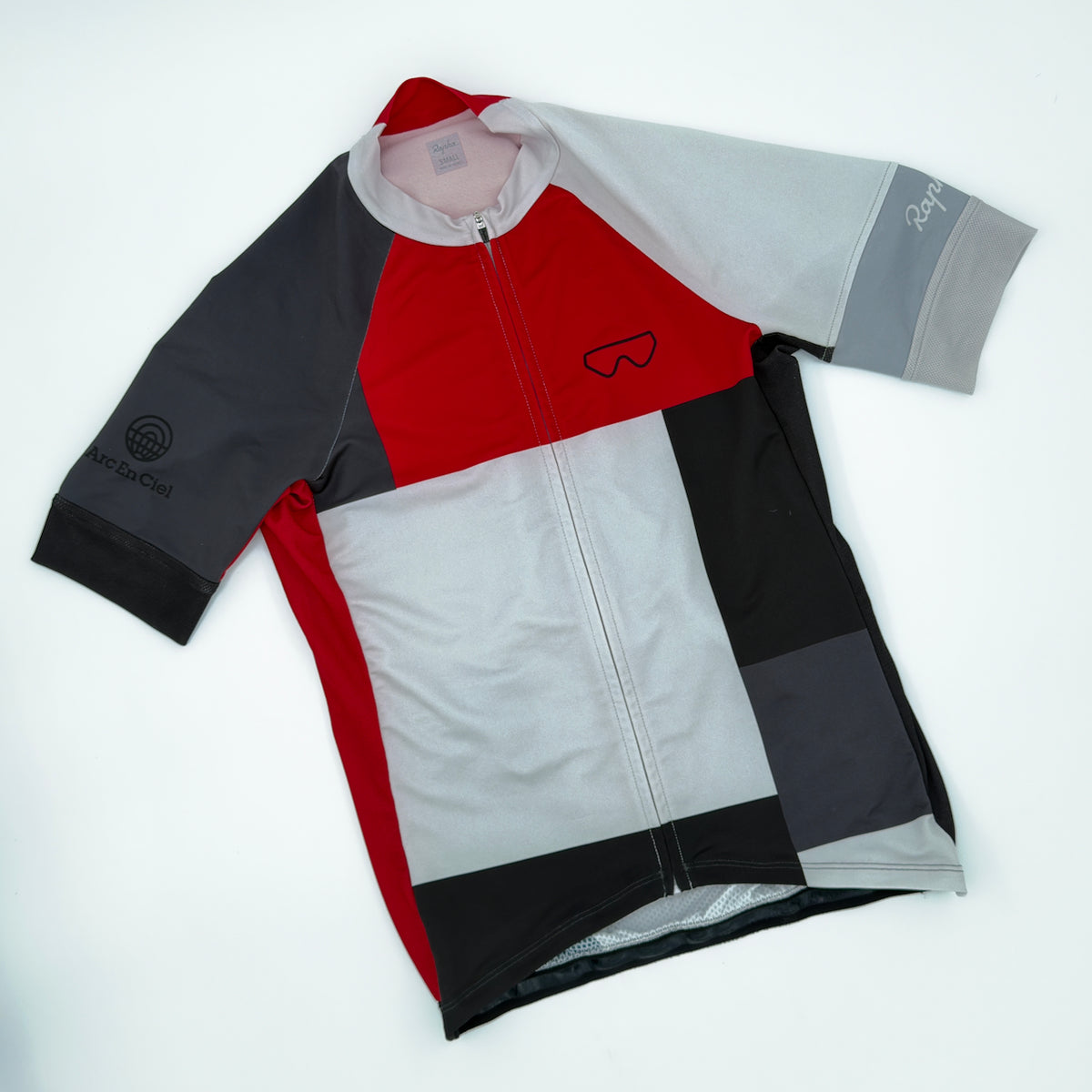 Rapha Trade Team Jersey angled front showing Oakley-style sunglasses chest graphic and Arc En Ciel sleeve print