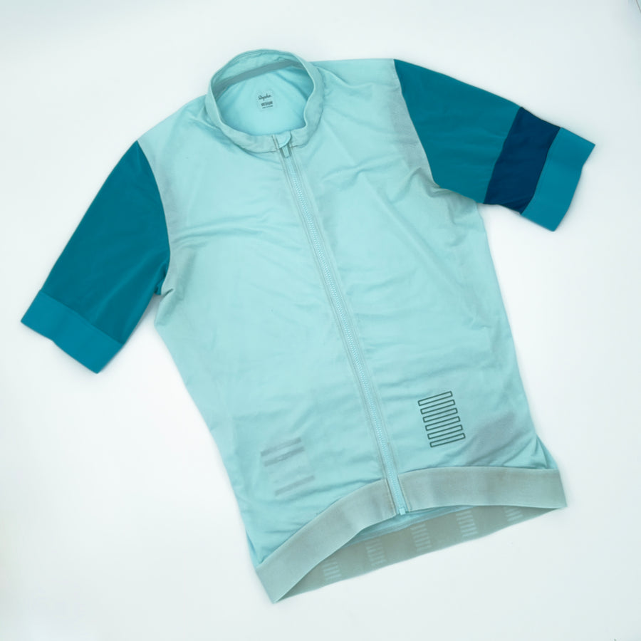 Rapha Pro Team Training Jersey angled front showing teal sleeves and petrol cuff band