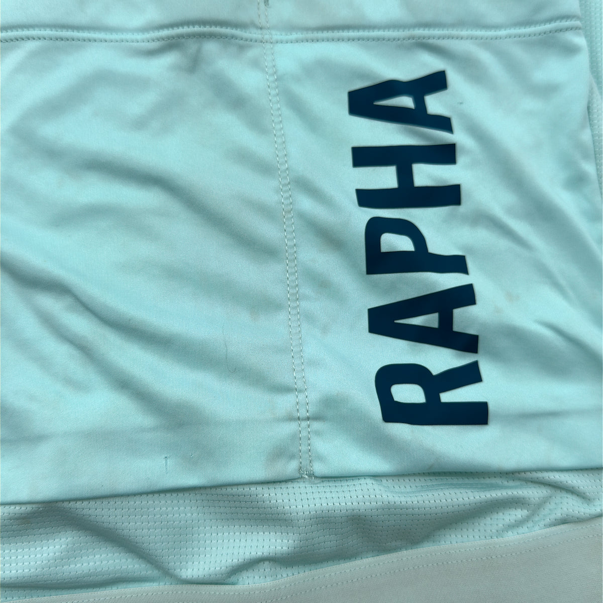 Close-up of small marks to the rear pocket panel beside the RAPHA print