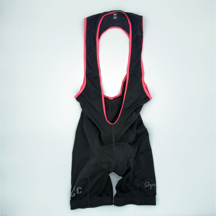 Rapha RCC Classic Bib Shorts II angled front showing black fabric with pink strap binding (alternate view)