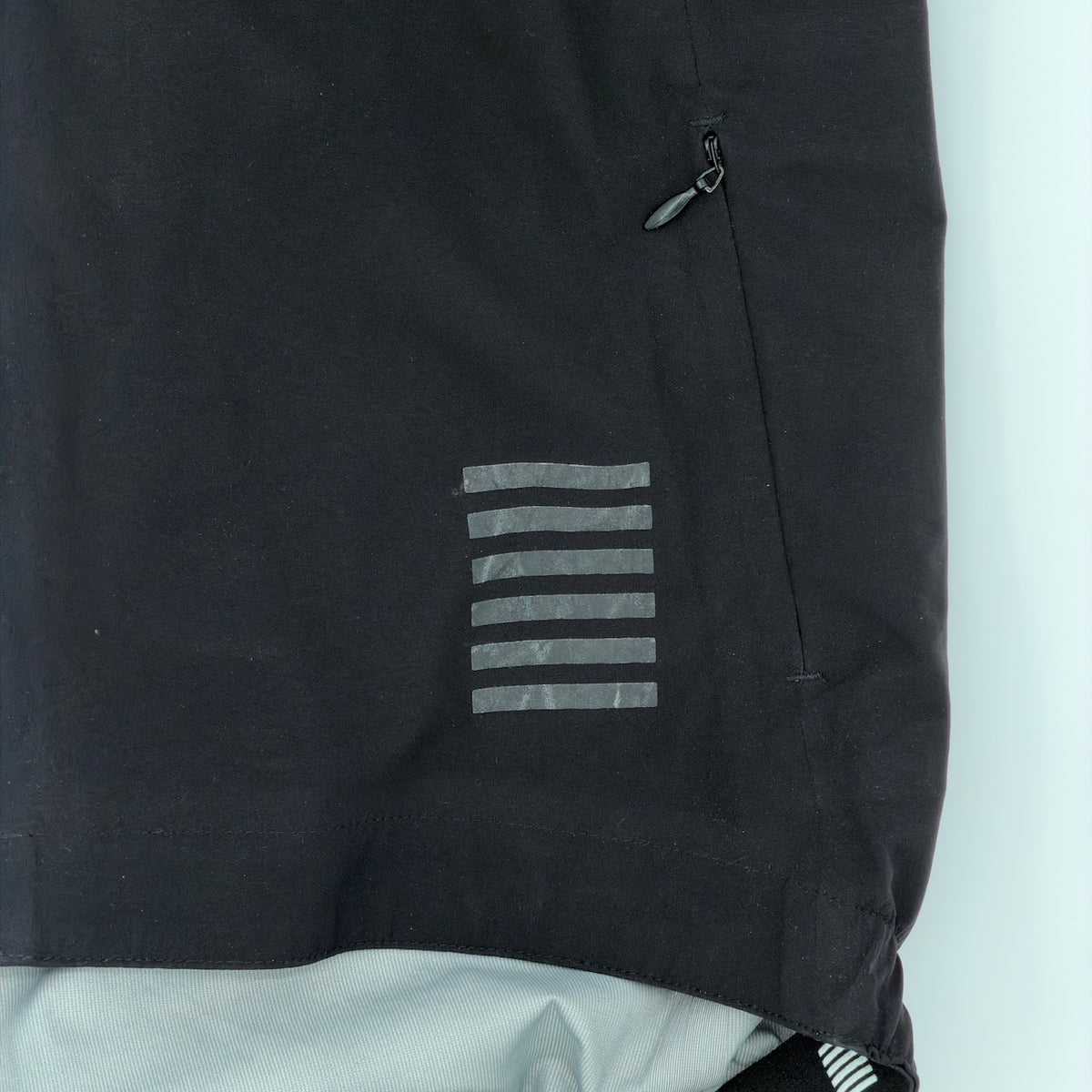 Close-up of the reflective bar-block motif and zipped side pocket
