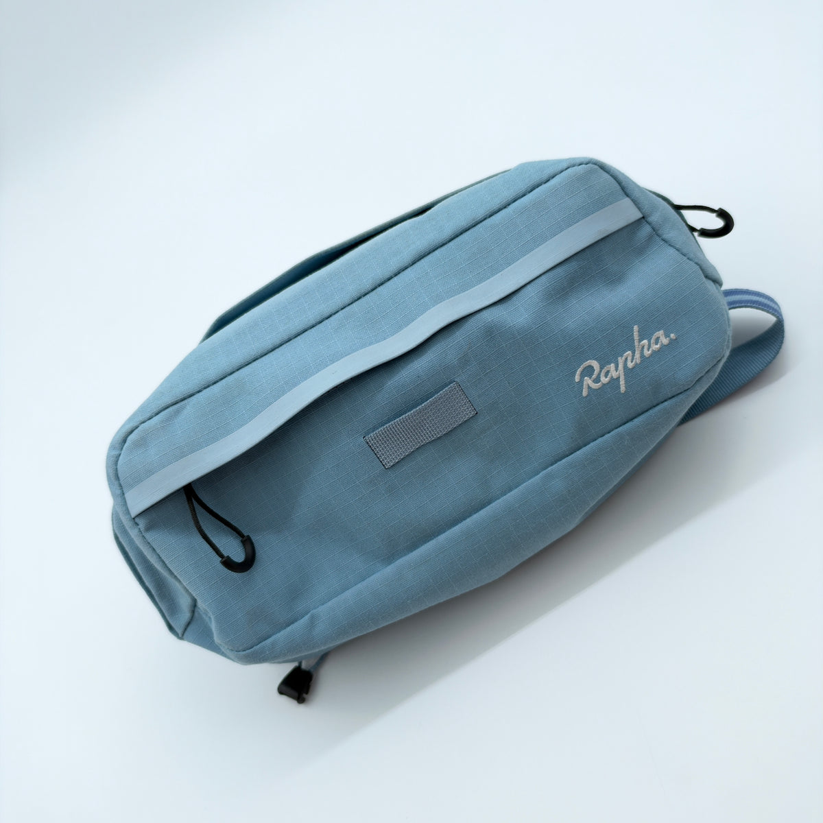 Angled front view showing the reflective band, Rapha script and velcro patch panel